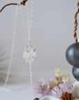 Side angle close-up of raw rainbow moonstone pendant showing 925 sterling silver prong setting on minimalist moonstone necklace.