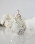 Back angle view of natural rainbow moonstone pendant highlighting detailed artisan wire wrapping in soft silver copper