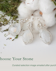 Three rainbow moonstone pendants showing natural variation in size and flash in handmade artisan jewelry
