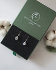 Rainbow moonstone sterling silver drop earrings in branded Designs by Nature Gems jewelry box, showcasing handcrafted faceted rainbow moonstone and sterling silver wire wrapping