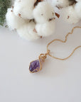 Raw amethyst necklace in 14k gold filled laying flat. Handcrafted February birthstone jewelry for women by Designs by Nature Gems.