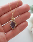 Raw amethyst necklace in 14k gold filled shown in hand for size reference. Artisan February birthstone pendant by Designs by Nature Gems.