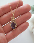 Raw amethyst necklace in 14k gold filled shown in hand for size reference. Artisan February birthstone pendant by Designs by Nature Gems.