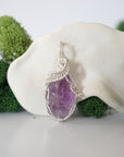 Close up front view of raw amethyst crystal with detailed 925 sterling silver wire wrapping