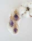 Three raw amethyst pendants in 14k gold filled, showing natural variation in size, shape, and color. Handcrafted February birthstone jewelry by Designs by Nature Gems.
