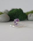 Back view of adjustable sterling silver ring with natural raw amethyst stone in claw setting