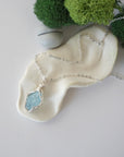 Simple raw aquamarine necklace with silver plated brass chain laying flat