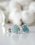Right side angle of raw aquamarine stud earrings, minimalist sterling silver claw setting, March birthstone