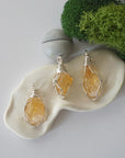 Three different raw citrine pendants displayed for variation reference
