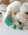 Left side view of raw emerald necklace pendant in 14k gold filled, showing artisan wire wrapping. Handcrafted May birthstone necklace by Designs by Nature Gems.