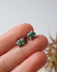 Natural raw emerald stud earrings in 14k gold vermeil shown in hand to display size and organic stone variation