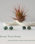 Two pairs of raw emerald stud earrings in sterling silver showing natural variation in emerald shape size and green colour