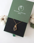Raw garnet necklace in 14k gold filled displayed in branded Designs by Nature Gems jewelry box. Artisan January birthstone gift for women.