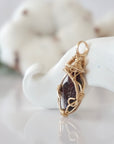 Side view of raw garnet pendant in 14k gold filled, showing artisan wire wrapping. Handcrafted January birthstone necklace by Designs by Nature Gems.