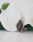 Back view of raw garnet necklace pendant with handcrafted sterling silver wire work