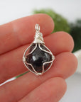 Simple raw garnet pendant shown in hand for size reference