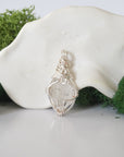 Back angle look at simple raw Herkimer diamond pendant with silver wire wrapping