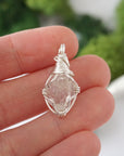 Simple raw Herkimer diamond pendant shown in hand for size reference