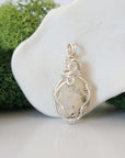 Back angle look at simple raw opal pendant with silver wire wrapping