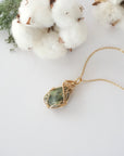 Raw peridot necklace in 14k gold filled laying flat. Handcrafted August birthstone jewelry for women by Designs by Nature Gems.