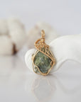 Detailed front view of raw peridot pendant in 14k gold filled. Unique wire wrapped August birthstone jewelry by Designs by Nature Gems.