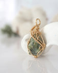 Side view of raw peridot pendant in 14k gold filled, showing artisan wire wrapping. Handcrafted August birthstone necklace by Designs by Nature Gems.