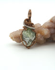 Front view of raw peridot pendant for men — natural sage olive green crystal with pale markings, antique bronze and dark silver wire wrap, handcrafted August birthstone jewelry