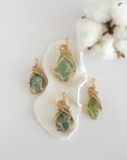 Four raw peridot pendants in 14k gold filled, showing natural variation in size, shape, and color. Handcrafted August birthstone jewelry by Designs by Nature Gems.