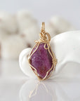 Back view of raw pink ruby pendant in 14k gold filled, highlighting stone and wire detail. One of a kind July birthstone jewelry by Designs by Nature Gems.