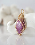 Side view of raw pink ruby pendant in 14k gold filled, showing artisan wire wrapping. Handcrafted July birthstone necklace by Designs by Nature Gems.