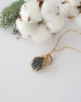 Raw sapphire necklace in 14k gold filled laying flat. Handcrafted September birthstone jewelry for women by Designs by Nature Gems.