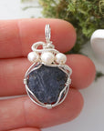 Raw sapphire and freshwater pearl pendant held in hand to show size — 925 sterling silver wire wrap, handcrafted crystal jewelry by Designs by Nature Gems