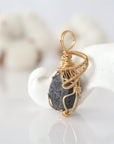 Side view of raw sapphire pendant in 14k gold filled, showing artisan wire wrapping. Handcrafted September birthstone necklace by Designs by Nature Gems.