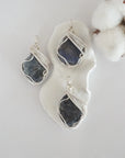 Three raw sapphire pendants showing natural variation in stone size, shape, and blue-grey tone — each one of a kind, September birthstone, silver wire wrapped, Designs by Nature Gems