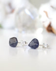 Slight-angle view of natural raw sapphire stud earrings on 925 sterling silver posts — minimalist September birthstone jewelry by Designs by Nature Gems