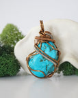 Back view of detailed wire wrapped raw turquoise pendant showing antique bronze copper craftsmanship and technique