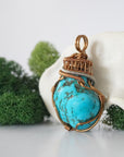 Side angle of raw turquoise pendant showing intricate wire wrap detail with tin plated copper accents and texture