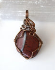 Back side angle view of natural red tiger's eye pendant, handcrafted jewelry by Designs by Nature Gems.