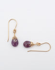 Closeup showing details of ruby drop earrings, faceted ruby stone, 14k gold filled setting
