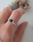 Woman wearing a minimalist silver wire-wrapped sapphire ring — natural September birthstone jewelry handcrafted by Designs by Nature Gems