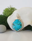 Front view of simple raw turquoise pendant with clean silver wire wrapping, minimalist handmade crystal jewelry