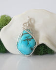 Front view of 925 sterling silver raw turquoise pendant showing detailed wire wrapping, handmade women's crystal jewelry