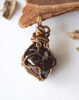 Back view of a women’s garnet wire wrapped pendant necklace in antique bronze copper, showing the detailed handcrafted wire wrapping