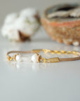 Side view of a women’s pearl and moonstone leather bracelet showing gold plated wire wrapping and leather strap
