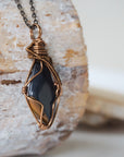 Right angle close-up of blue tiger's eye necklace for men – detailed antique bronze copper wire wrapping, natural crystal.
