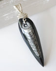 Front angle close-up of Orthoceras fossil pendant for men – detailed 925 sterling silver wire wrapping, prehistoric fossil, minimalist style.