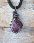 Handcrafted raw ruby necklace for men, front view – artisan antiqued sterling silver wire wrapping, July birthstone, black leather cord.
