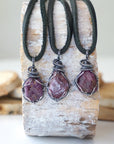 Three raw ruby pendants for men – showing natural variation in size, shape, and red shade, black leather cord.