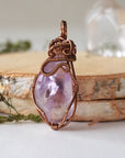 Back side angle of women’s amethyst pendant, lighter violet stone, antique bronze copper wire wrap