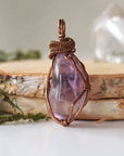 Front side angle of women’s amethyst pendant, lighter violet stone, antique bronze copper wire wrap